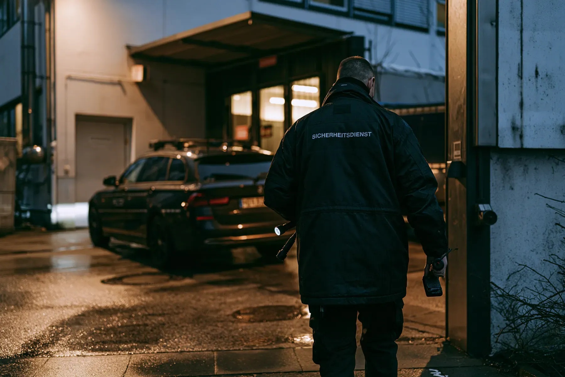 Rundgang mit Taschenlampe und Funkgerät über einen Betriebshof bei Nacht